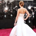 Image of a woman in a white dress standing on the red carpet